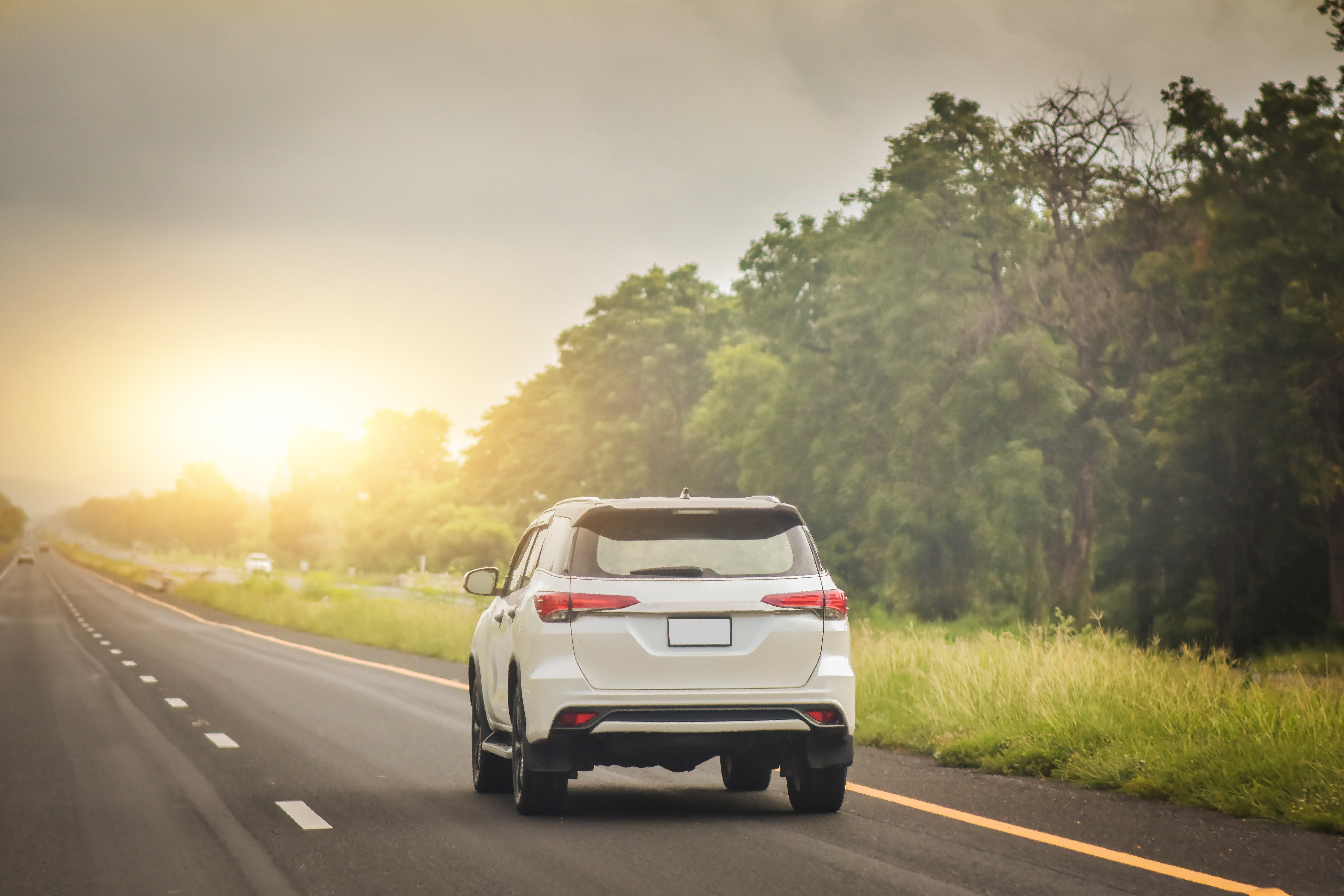 A relocated individual driving their car along the road which was successfully transported internationally with them 